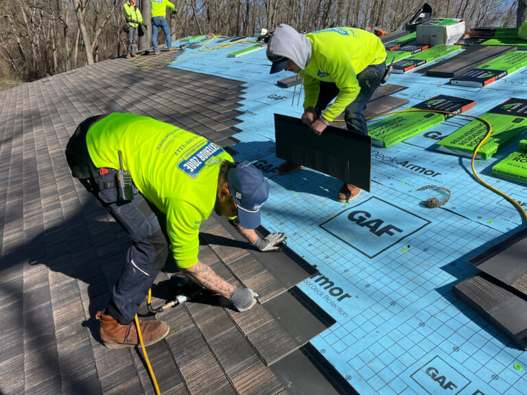 Roofing professionals from The Exterior Zone installing F-WAVE® REVIA® Hand Split Shake synthetic shingles over GAF Deck Armor underlayment.