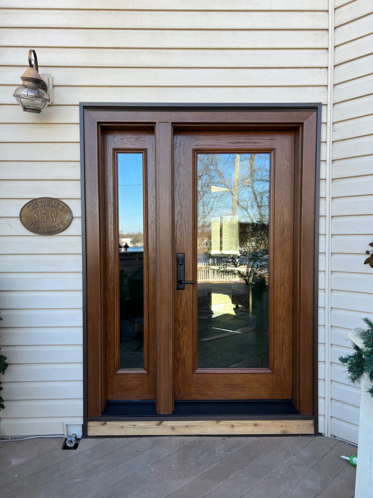 Exterior view of a newly installed ProVia entry door with sidelites in caramel oak finish, located at the Thulin residence.